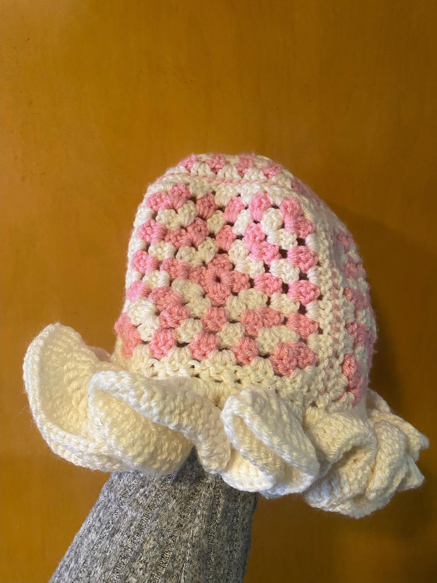 Crocheted Granny square hat with ruffled rim
