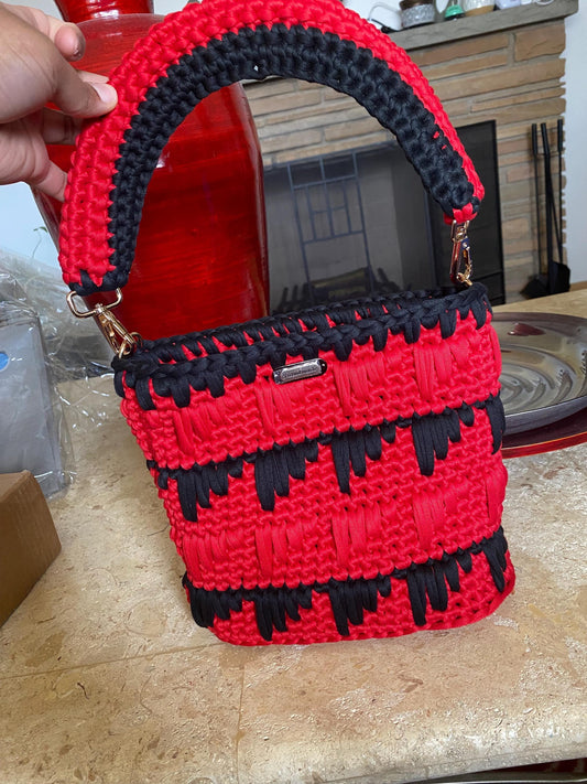 Black and red crocheted purse with leather bottom.
