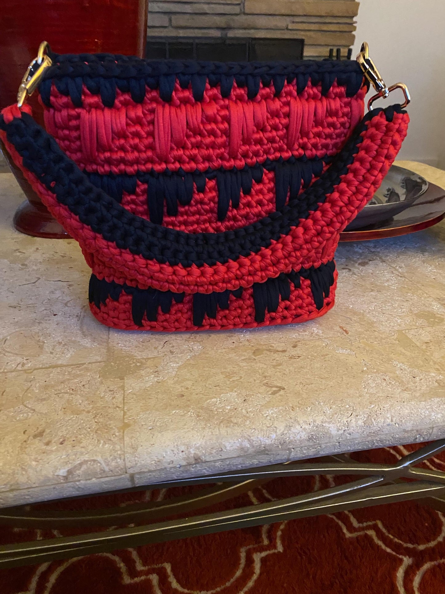 Black and red crocheted purse with leather bottom.