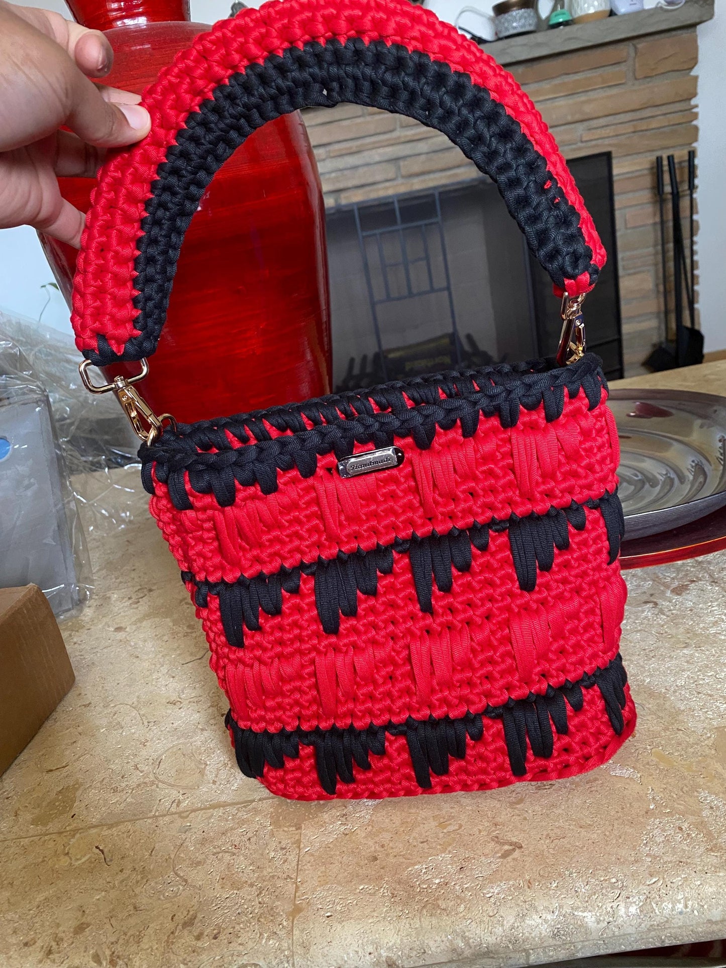 Black and red crocheted purse with leather bottom.