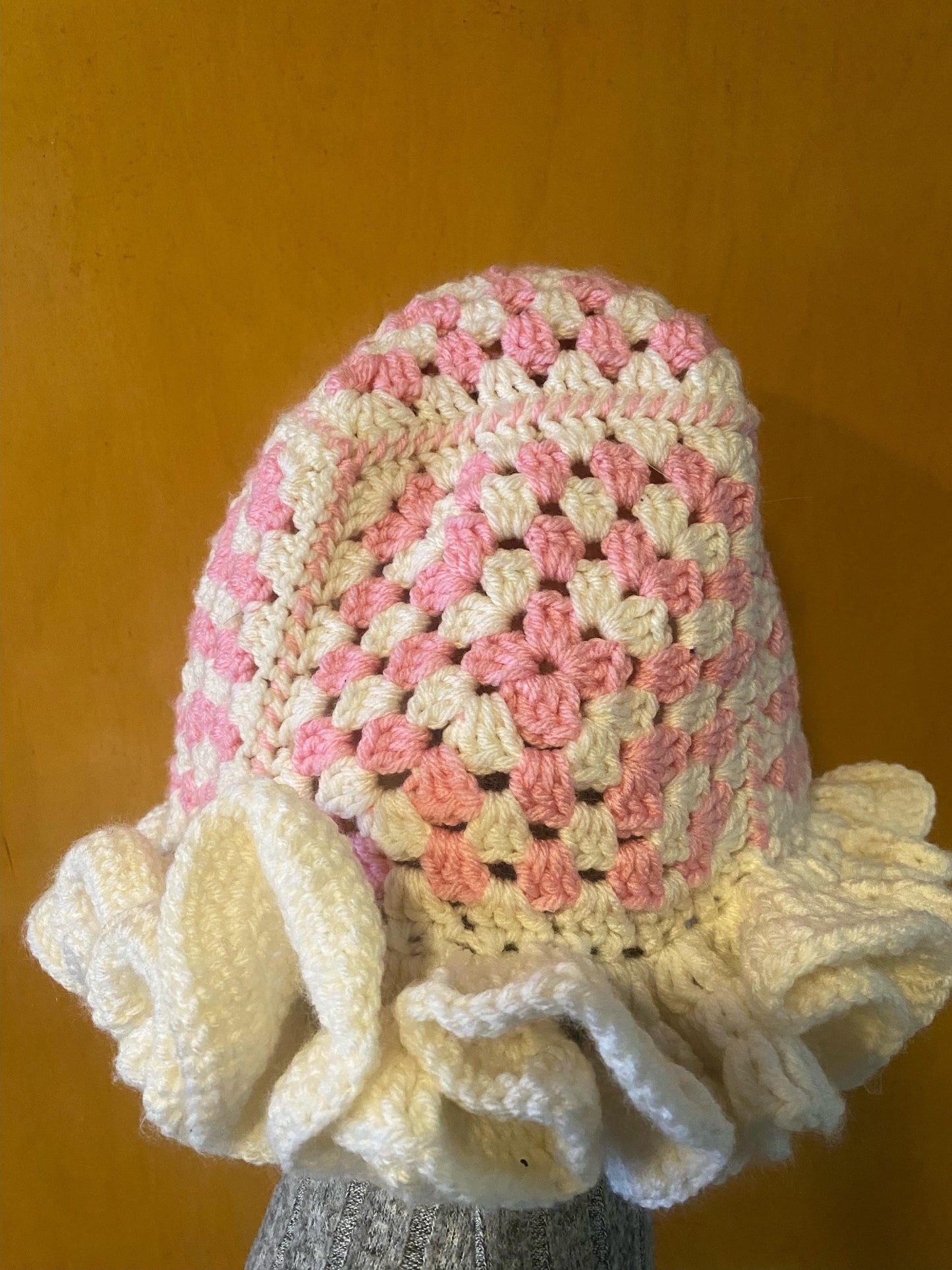 Crocheted Granny square hat with ruffled rim