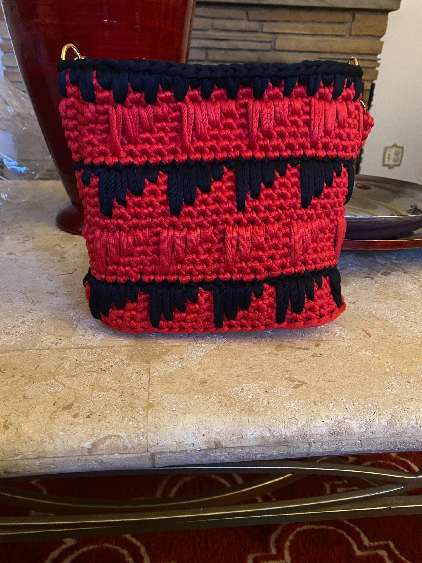 Black and red crocheted purse with leather bottom.